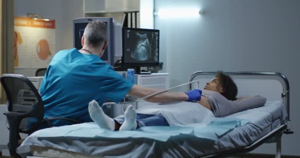 Lekarz bada kobietę z ultradźwiękami — Wideo stockowe