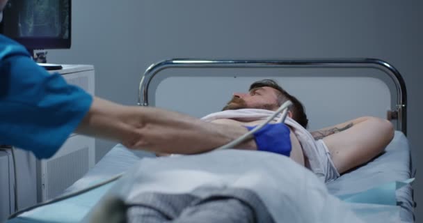 Doktor zkoumá muže s ultrazvukem — Stock video