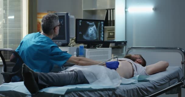 Doctor examining man with ultrasound — Stock Footage Doctor examining man with ultrasound Stock Footage