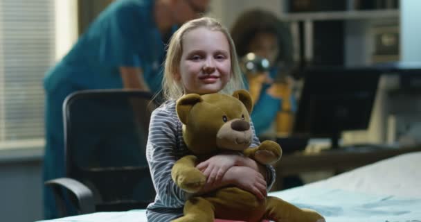 Girl sitting in hospital with teddy bear — Stock Video