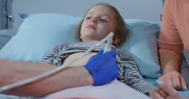 Doctor examining girls abdomen with ultrasound — Stock Footage Doctor examining girls abdomen with ultrasound Video Clip