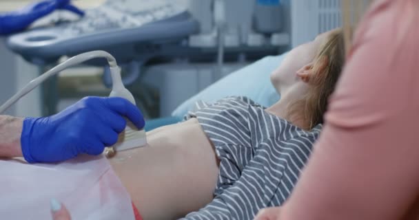 Médecin examinant le ventre des filles avec échographie — Video