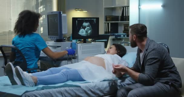 Arts afwerking echografie onderzoek op zwangere vrouw — Stockvideo