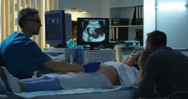 Gelecek çocuğun ultrason görüntüsünü izleyen çift