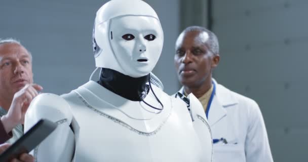 Cientistas examinando um robô humanoide — Vídeo de Stock