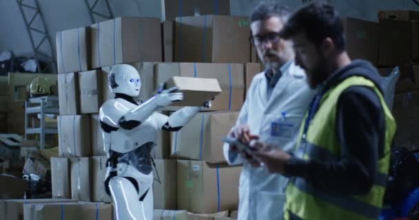 Robot die box naar technici in een magazijn brengt — Stockvideo