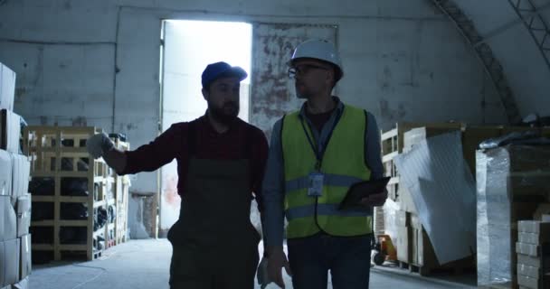 Mühendis ve foreman bir depoda konuşuyor — Stok video