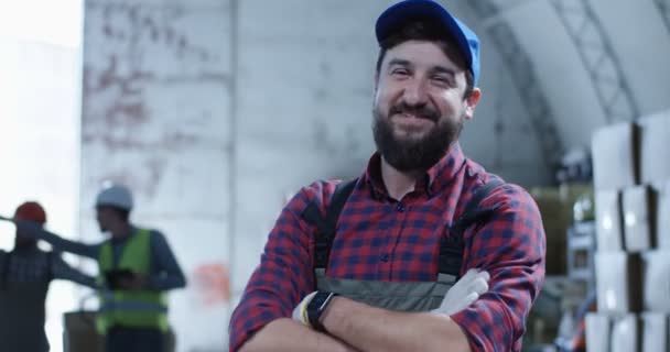 Рабочий улыбается в камеру на складе — стоковое видео