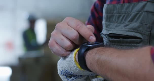 Arbetstagare som använder smartwatch i ett lager — Stockvideo