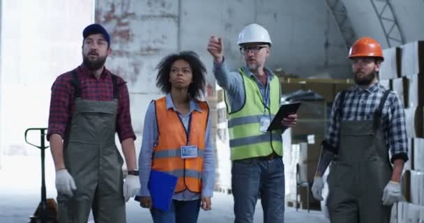 Engenheiro dando instruções em um armazém — Vídeo de Stock