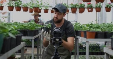 Bahçıvan kameraya bitki sunan