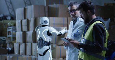 Robot bir depoda teknisyenler için kutu getiren