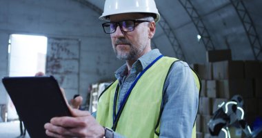 Depodaki robotu denetleyen mühendis