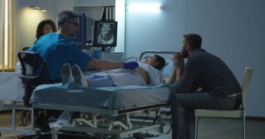 Gelecek çocuğun ultrason görüntüsünü izleyen çift