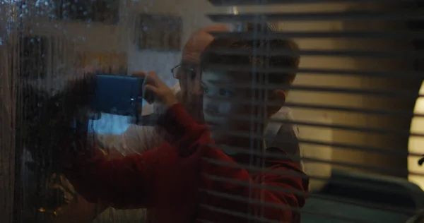 Мальчик смотрит шторм через окно — стоковое фото