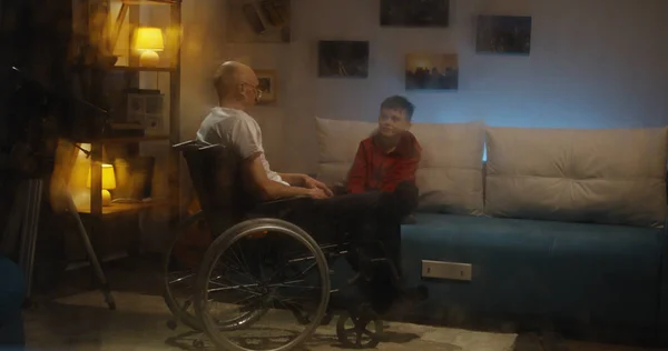 Oudere wheelvoorgezeten man praat met zijn kleinzoon — Stockfoto