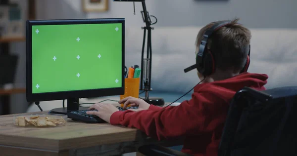 Wheelchaired boy using computer — Stockfoto