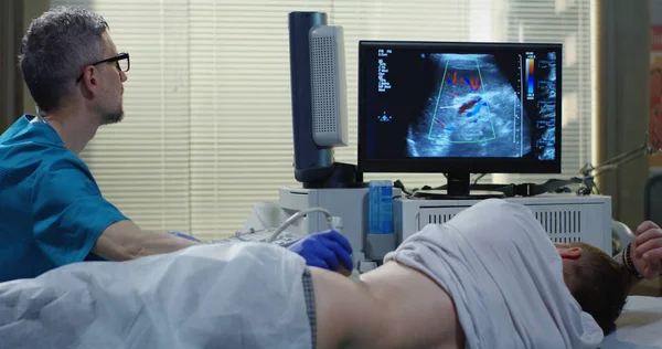 Læge undersøger mand med ultralyd - Stock-foto