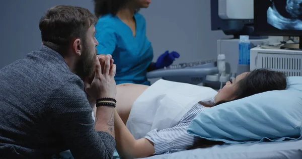 Læge undersøger gravid kvinde med ultralyd - Stock-foto