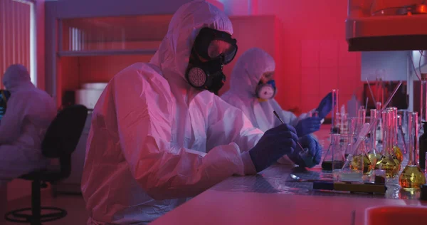 Οι επιστήμονες κάθονται και εργάζονται σε εργαστηριακές — Φωτογραφία Αρχείου