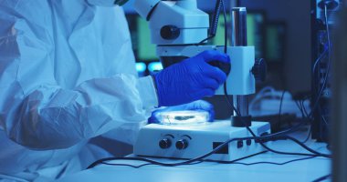 Mikroskopla numuneyi inceleyen bilim adamı