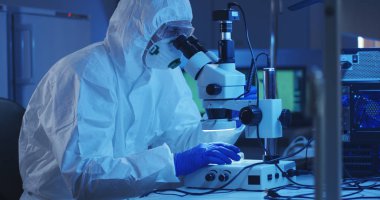 Mikroskopla numuneyi inceleyen bilim adamı