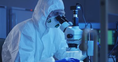 Mikroskopla numuneyi inceleyen bilim adamı