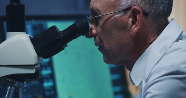 Wetenschapper onderzoekt bacteriën met Microscoop — Stockfoto