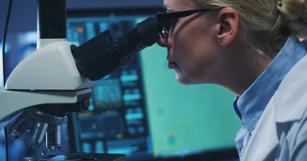 Cientista examinando bactérias com microscópio — Fotografia de Stock