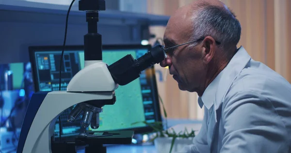 Vědec vyšetřující bakterie v mikroskopu — Stock fotografie