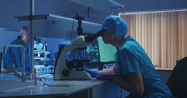 Biologist analyzing sample with microscope — Stock Photo, Image