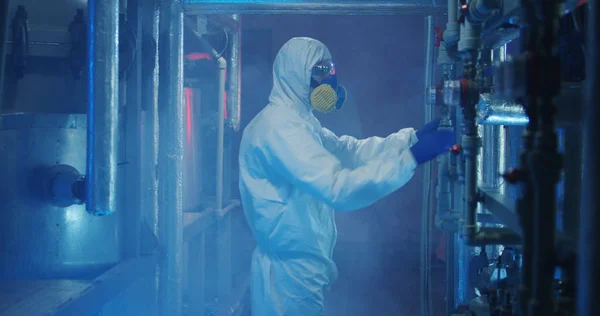 Scientists in hazmat suits checking equipment
