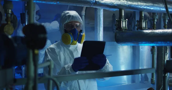 Scientists in hazmat suit conducting maintenance — Stock Photo, Image