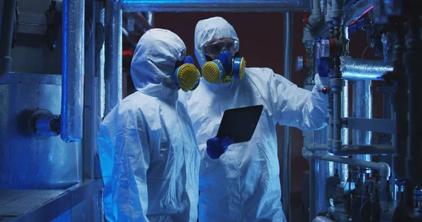 Επιστήμονες σε στολές επικίνδυνων υλικών που διεξάγουν εργασίες συντήρησης — Φωτογραφία Αρχείου