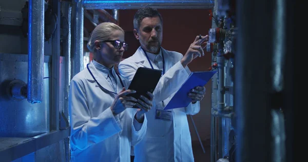 Cientistas verificando medidor de pressão — Fotografia de Stock