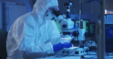 Mikroskopla numuneyi inceleyen bilim adamı