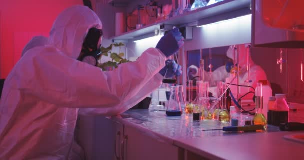 Scientists working in laboratory in red light — Stock Video