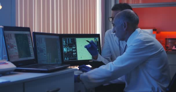 Cientistas observando monitor e analisando — Vídeo de Stock