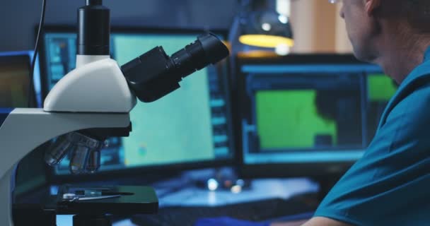 Biologe analysiert Probe mit Mikroskop — Stockvideo