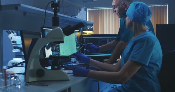 Scienziati che esaminano i batteri al microscopio — Video Stock