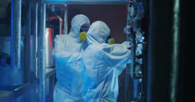 Hazmat takım elbiseli bilim adamları ekipman kontrol