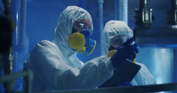 Vědci v rohožových oblecích provádějících údržbářské práce — Stock video