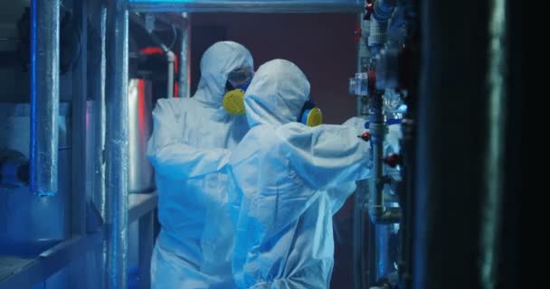 Scientists in hazmat suits checking equipment — Stock Video