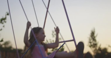 Gün batımında sallanan kız