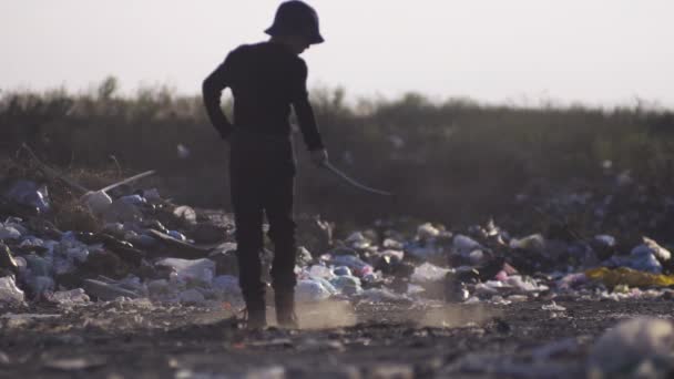 Uttråkad pojke att göra damm i dump — Stockvideo