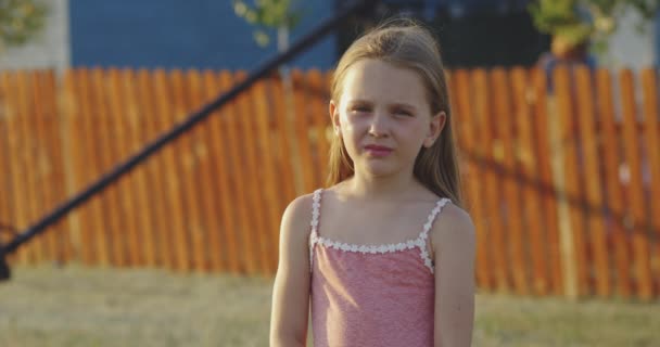 Маленька дівчинка посміхається і позує — стокове відео