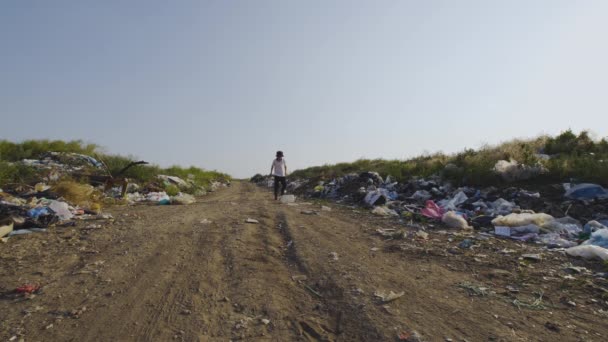 Pojke leker med pinne och kan i dump — Stockvideo