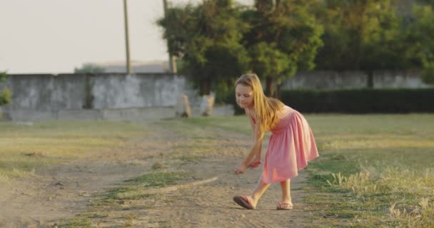 Girl playing with stick in field — Stock Video