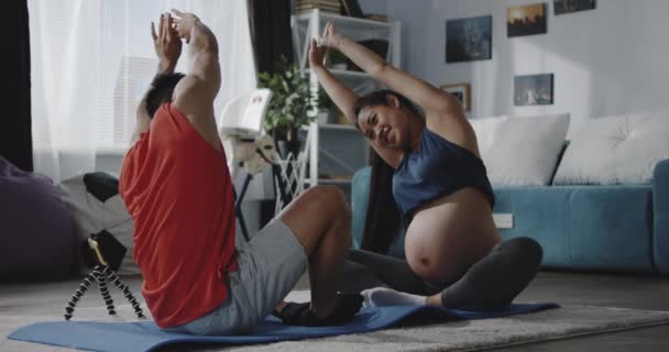 Fiatal férfi a terhes nőt oktató edzés közben — Stock videók