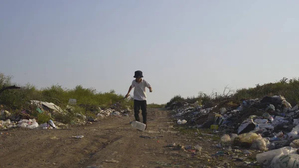 Chico pateando plástico lata en volcado — Foto de Stock